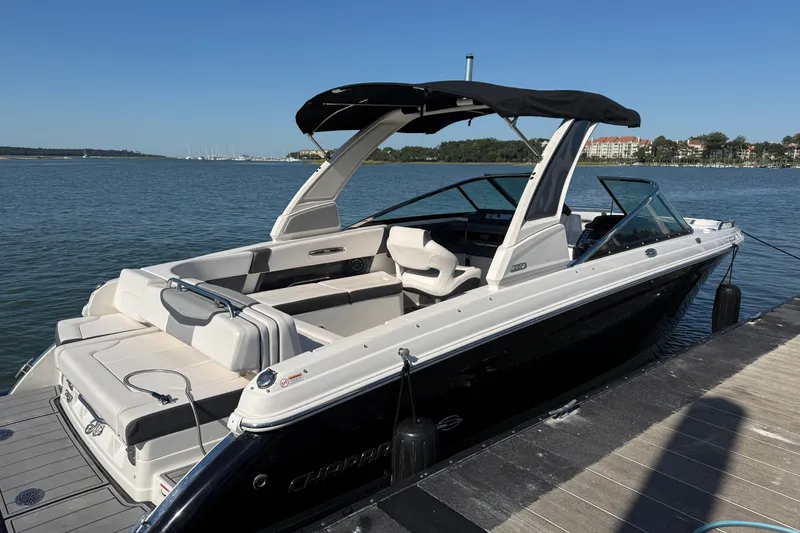 Slide: The Image of 2021 Chaparral 307 SSX boat docked on a sunny day, showcasing sleek design and spacious seating. - 45