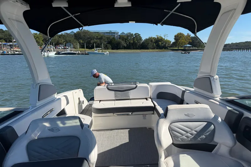 Slide: The Image of 2021 Chaparral 307 SSX boat interior with seating, on a calm lake. - 28