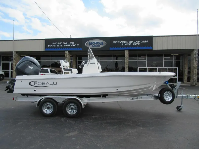 Slide: The Image of Robalo 206 Pro 2027 on a trailer parked in front of a boat dealership. - 1