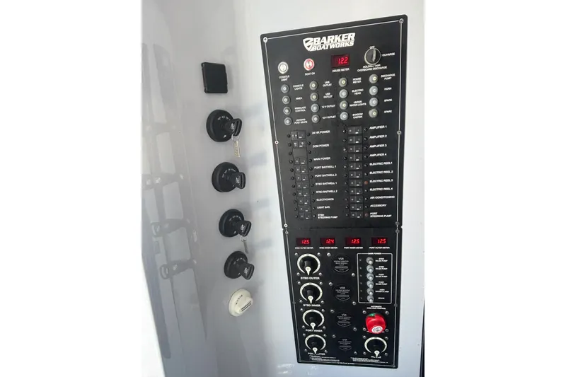 Slide: The Image of Control panel of 2023 Barker Boatworks 40 HPC, featuring switches and gauges. - 10