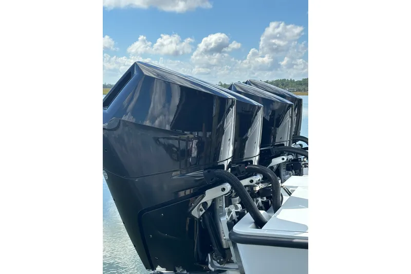 Slide: The Image of Triple outboard engines on a 2023 Barker Boatworks 40 HPC under a clear sky. - 26
