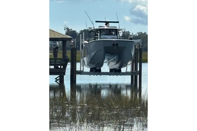 Slide: The Image of 2023 Barker Boatworks 40 HPC on a lift over water, surrounded by greenery. - 1