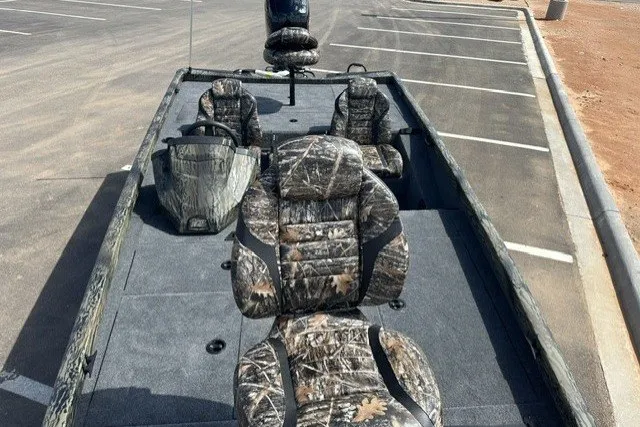 Slide: The Image of 2027 Ranger RT198P boat with camouflage seats in a parking lot. - 16