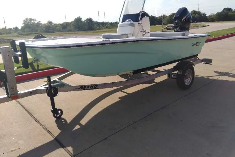 Slide: The Image of 2026 Mako Pro Skiff 13 CC boat on trailer, parked outdoors. - 1