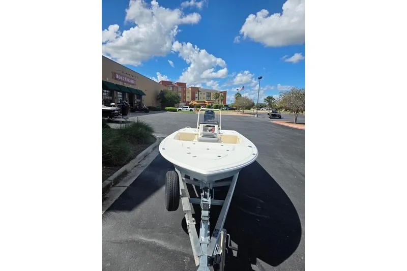 Slide: The Image of 2026 Mako 18 Pro Skiff boat on trailer in parking lot under blue sky. - 5