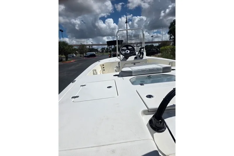 Slide: The Image of 2026 Mako 18 Pro Skiff boat with steering console under cloudy sky. - 7