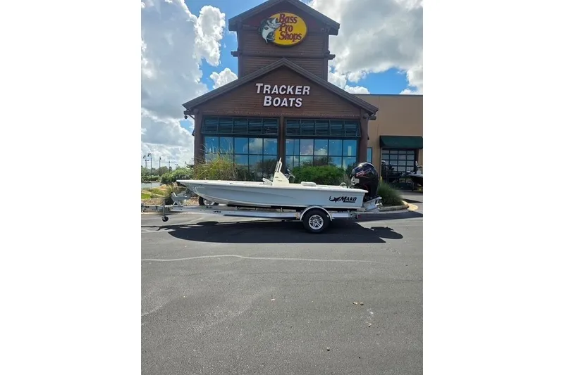 Slide: The Image of 2026 Mako 18 Pro Skiff boat on trailer outside Bass Pro Shops Tracker Boats. - 1