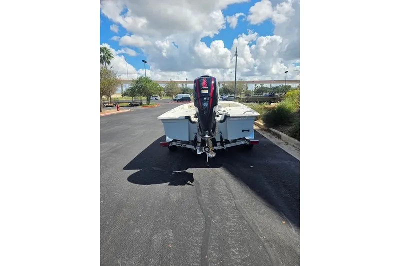 Slide: The Image of 2026 Mako 18 Pro Skiff boat on trailer, parked outdoors under a cloudy sky. - 11