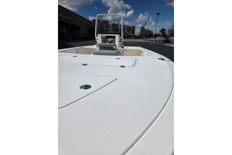 Slide: The Image of 2026 Mako 18 Pro Skiff boat deck with console, under a partly cloudy sky. - 6