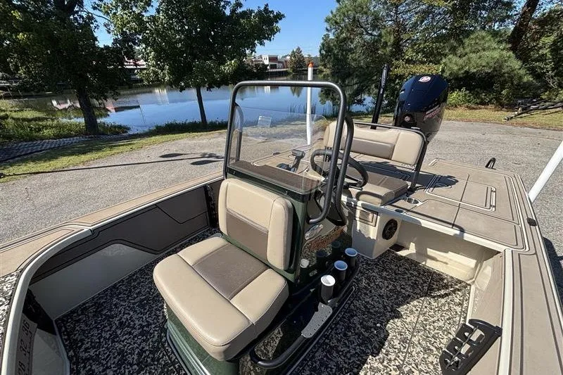 Slide: The Image of 2025 Mako 18 Pro Skiff Backwater Edition boat interior by a serene lake. - 24