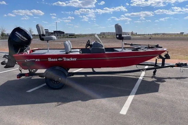 Slide: The Image of 2027 Tracker Bass Tracker Classic XL boat in a parking lot under a blue sky. - 15