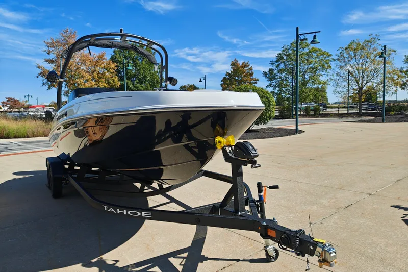 Slide: The Image of 2027 Tahoe T21 boat on trailer, parked outdoors under clear blue sky. - 5