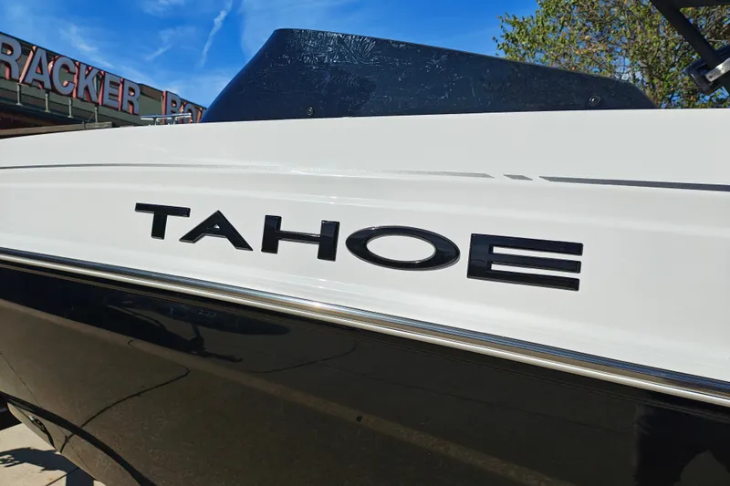 Slide: The Image of 2027 Tahoe T21 boat with sleek design and bold logo under clear blue sky. - 2