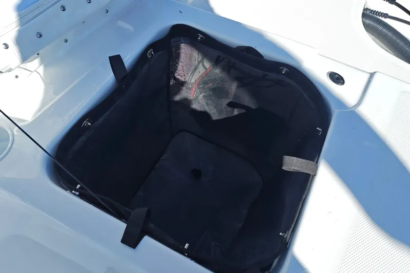 Slide: The Image of Storage compartment on a 2027 Tahoe T21 boat, featuring a black mesh liner. - 47