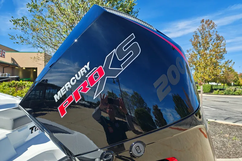 Slide: The Image of Mercury Pro XS 200 engine on 2027 Tahoe T21 boat, outdoors with trees and blue sky. - 8