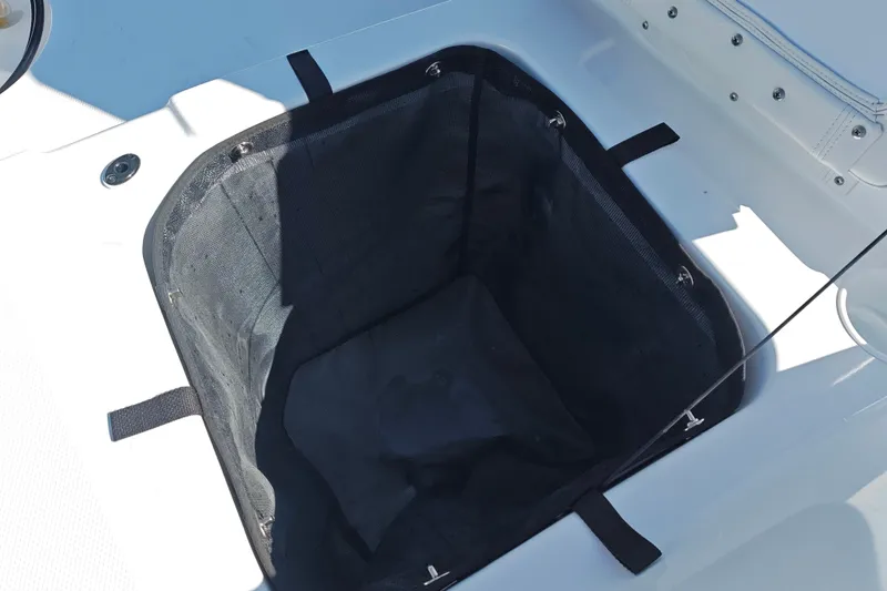 Slide: The Image of Storage compartment in 2027 Tahoe T21 boat, featuring a black mesh liner. - 46