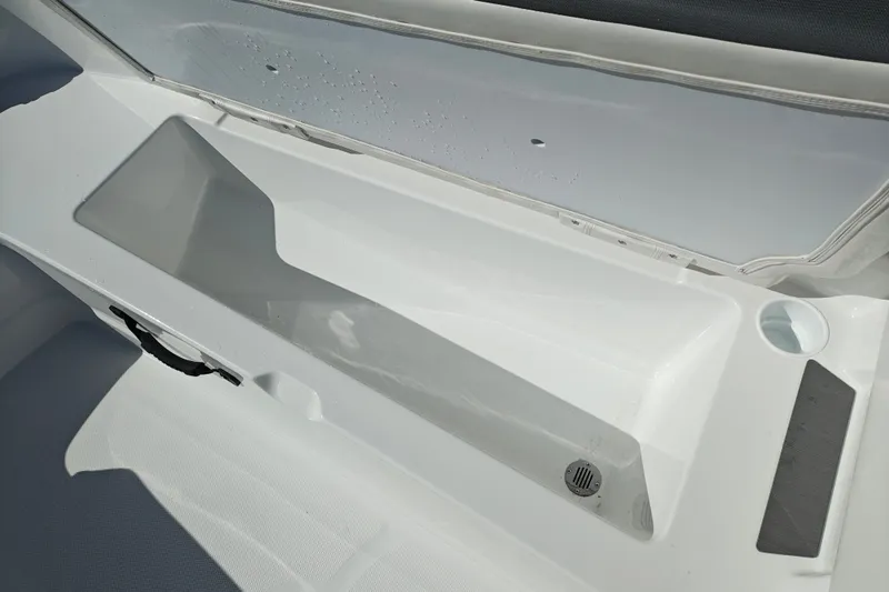 Slide: The Image of 2027 Tahoe T21 boat storage compartment with open lid and drainage feature. - 28