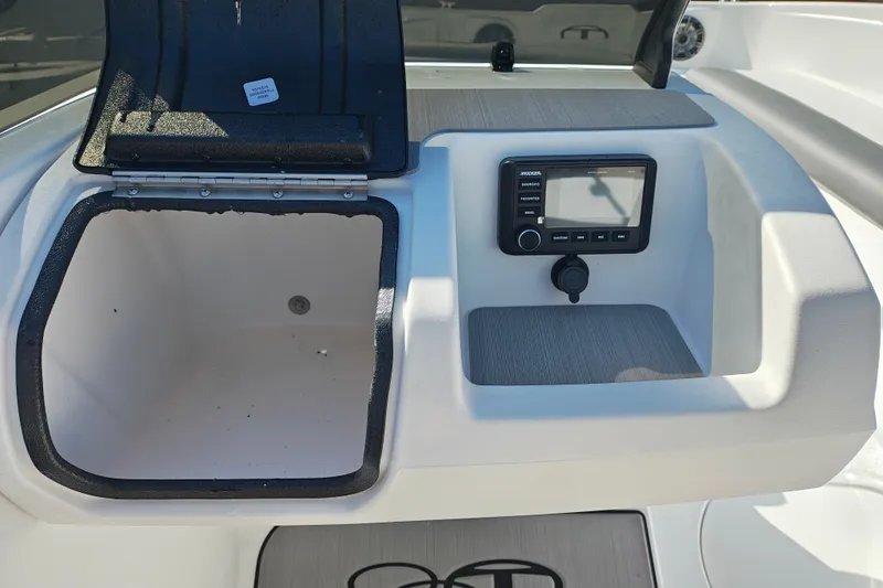 Slide: The Image of 2027 Tahoe T21 boat dashboard with open storage compartment and control panel. - 22