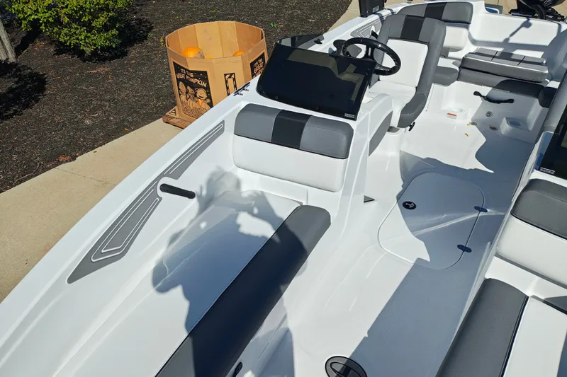Slide: The Image of 2027 Tahoe T21 boat interior with gray seating, steering wheel, and pumpkin box nearby. - 36