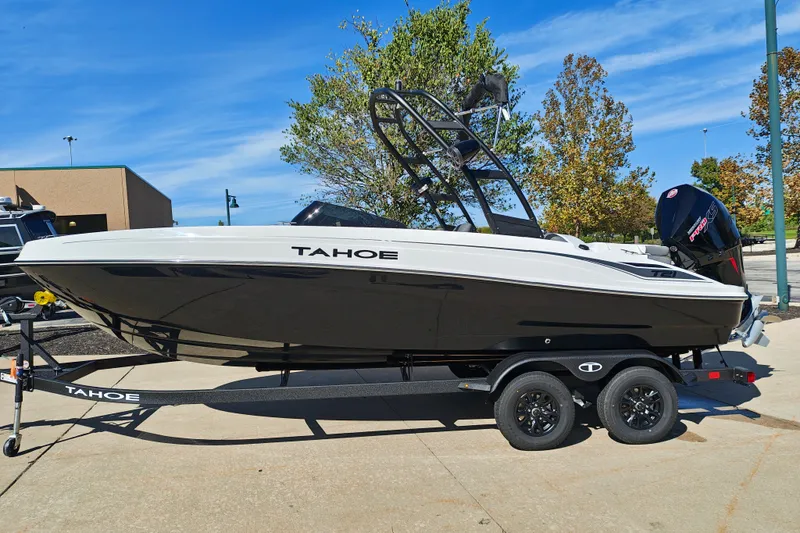 The Image of 2027 Tahoe T21 boat on trailer, black and white design, parked outdoors. - 0