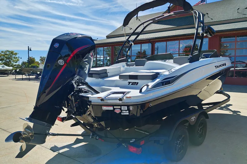 Slide: The Image of 2027 Tahoe T21 boat with powerful outboard motor, parked outdoors on a sunny day. - 6