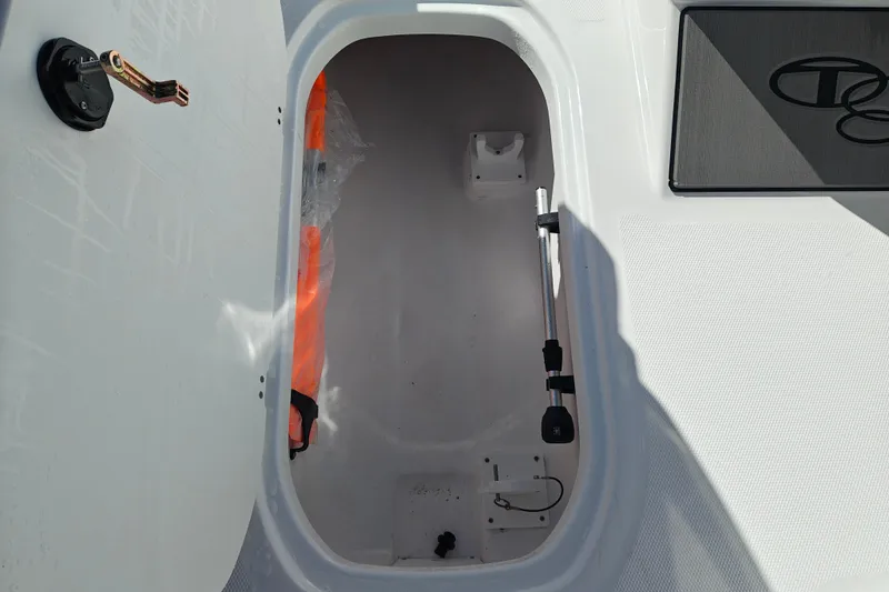 Slide: The Image of Open storage compartment in 2027 Tahoe T21 boat, featuring hydraulic support and safety equipment. - 25