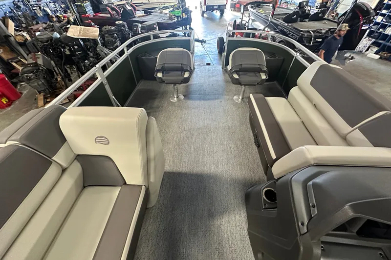 Slide: The Image of 2027 Sun Tracker Fishin' Barge 22 DLX interior with seating and helm in showroom. - 13
