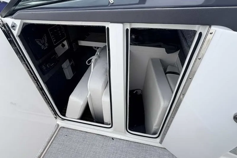 Slide: The Image of 2023 Formula 310 Bowrider I/O interior storage compartment with white cushions and sleek design. - 25