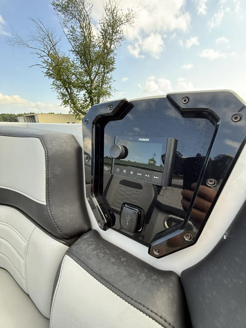 Slide: The Image of Close-up of a modern boat audio system with a Fusion display, surrounded by cushioned seating. - 10