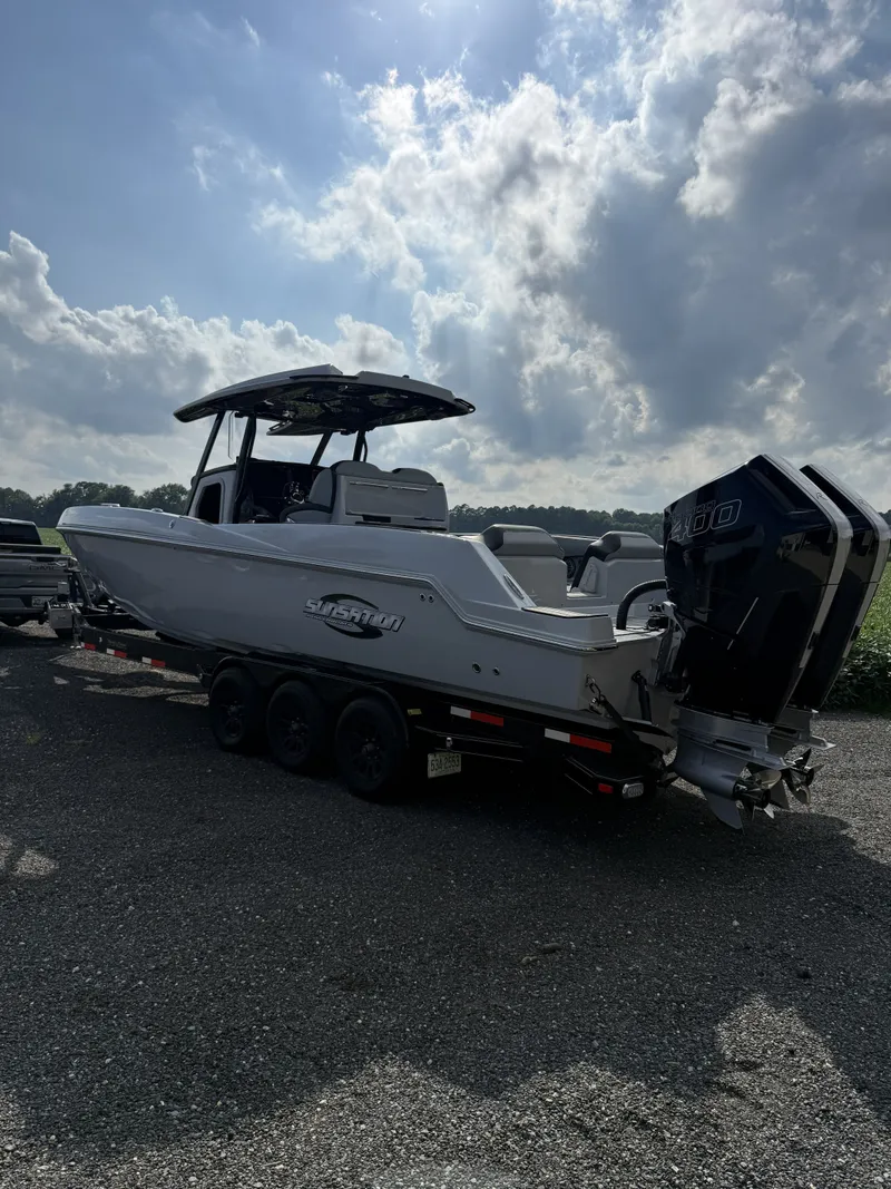Slide: The Image of A 2024 Sunsation 32 CCX boat on a trailer under a cloudy sky. - 3