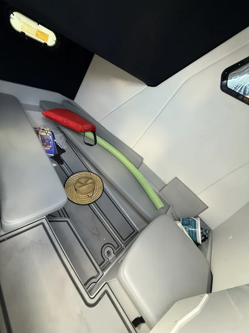 Slide: The Image of The interior of a boat with gray cushions, a hat, a pool noodle, and a red cushion. - 12