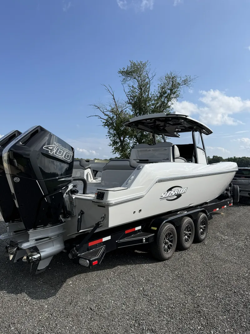Slide: The Image of A 2024 Sunsation 32 CCX boat on a trailer with two powerful outboard engines. - 2