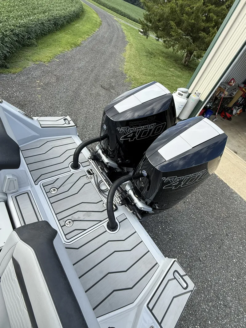 Slide: The Image of Two powerful outboard engines are mounted on the stern of a boat, parked on a paved path. - 7