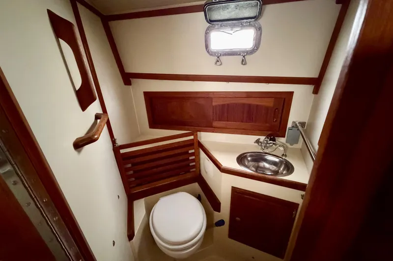 Slide: The Image of 1997 Pacific Seacraft Crealock 37 yacht bathroom with wooden accents and stainless steel sink. - 60