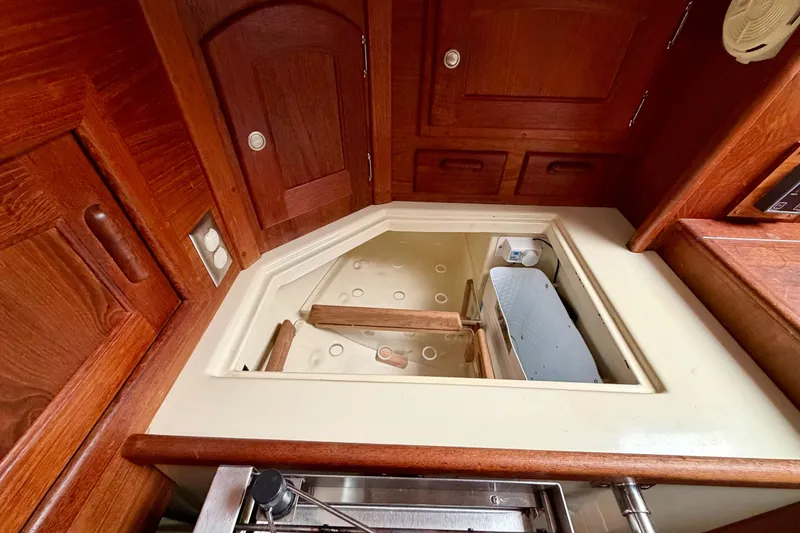 Slide: The Image of Interior of 1997 Pacific Seacraft Crealock 37 sailboat with wooden cabinetry and storage compartment. - 26