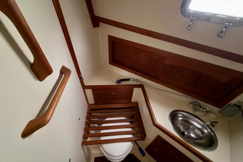 Slide: The Image of 1997 Pacific Seacraft Crealock 37 yacht bathroom with wooden accents and stainless steel sink. - 65