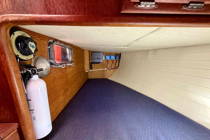 Slide: The Image of Interior of 1997 Pacific Seacraft Crealock 37 sailboat, featuring wood paneling and safety equipment. - 45
