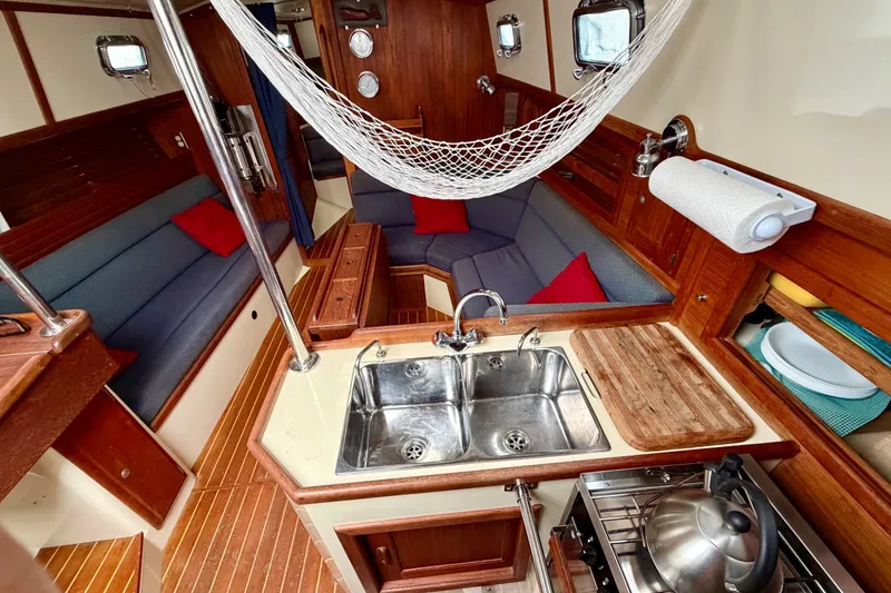 Slide: The Image of Interior of 1997 Pacific Seacraft Crealock 37 sailboat with cozy seating and kitchen area. - 35