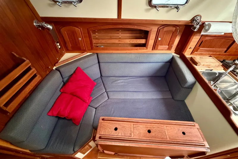 Slide: The Image of Interior of 1997 Pacific Seacraft Crealock 37 with cozy seating and wooden cabinetry. - 54