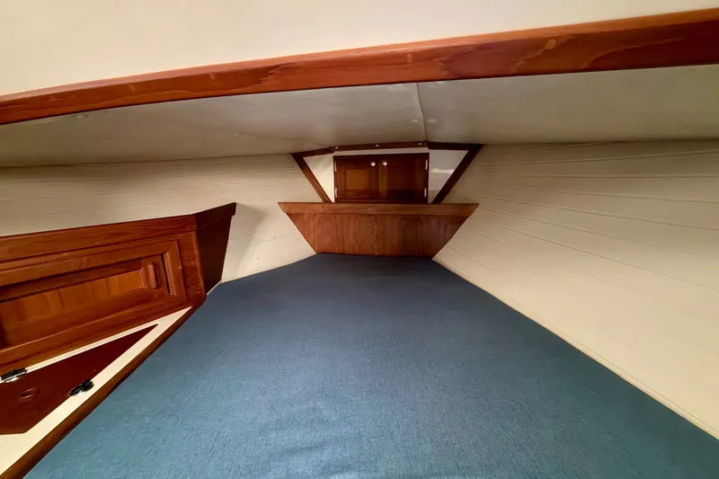 Slide: The Image of Interior cabin of 1997 Pacific Seacraft Crealock 37 sailboat, featuring wood paneling and blue carpeting. - 75
