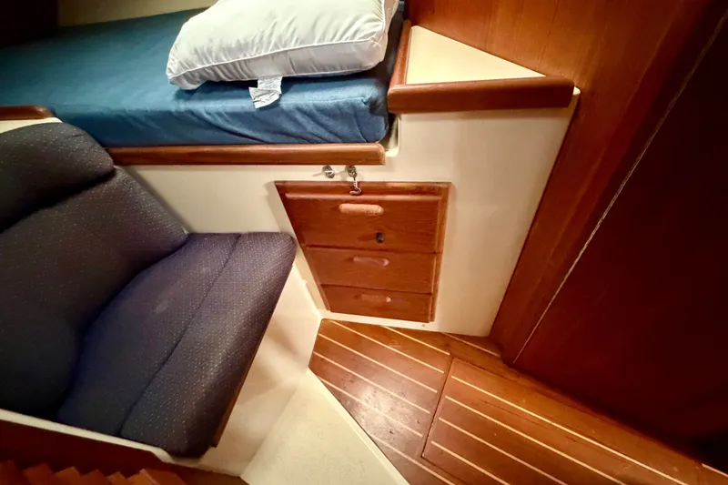 Slide: The Image of Interior of 1997 Pacific Seacraft Crealock 37 with bed, chair, and wooden cabinetry. - 78