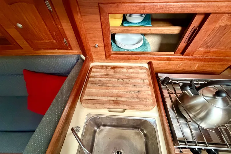 Slide: The Image of Galley of 1997 Pacific Seacraft Crealock 37 with wooden cabinetry and stainless steel sink. - 34