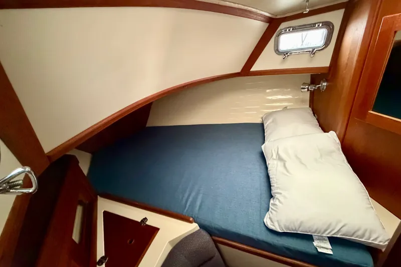 Slide: The Image of Cozy cabin interior of 1997 Pacific Seacraft Crealock 37 sailboat with blue bedding. - 68