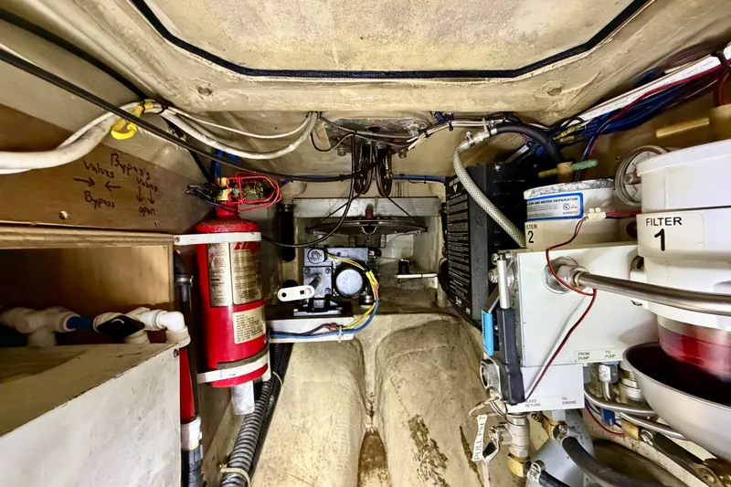Slide: The Image of Engine compartment of a 1997 Pacific Seacraft Crealock 37 sailboat, featuring filters and fire extinguisher. - 42