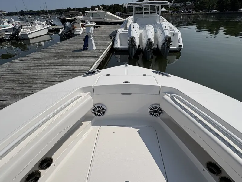 Slide: The Image of The image shows the bow of a Regulator 25 boat docked at a calm marina. - 44