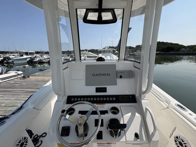 Slide: The Image of The image shows the cockpit of a Regulator 25 boat with Garmin navigation system, docked at a marina. - 28