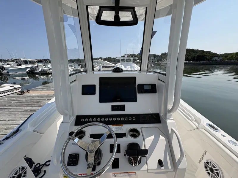 Slide: The Image of The image shows the helm of a 2025 Regulator 25 boat docked at a marina. - 30