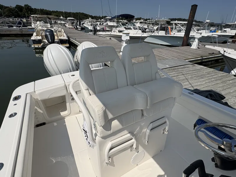 Slide: The Image of The image shows a 2025 Regulator 25 boat with white seats at the dock. - 26