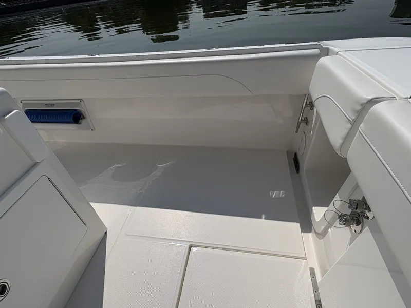 Slide: The Image of The image shows the cockpit of a 2025 Regulator 25 boat with white upholstery. - 17