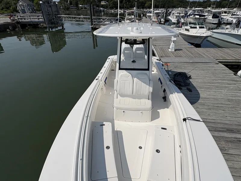 Slide: The Image of The image shows a modern boat docked at a pier. It features a spacious deck and protective canopy. - 46